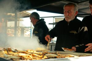 Koch am Grill bei einem Eventservice mit BBQ-Station und frisch zubereitetem Fleisch