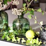Sommerliche Tischdeko mit grünen Glasvasen und Blumen