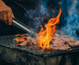 Saftiges Fleisch auf dem Grill mit offener Flamme – perfekte Szene für Grillrezepte